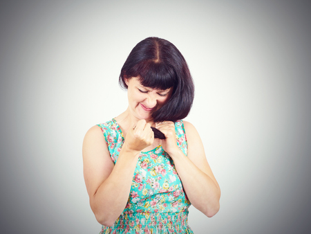 young woman in green dress looks at her problematic hairs.の写真素材