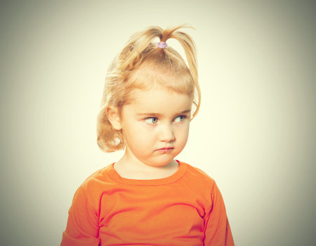 Little Funny girl in orange blouse. Isolated on white background