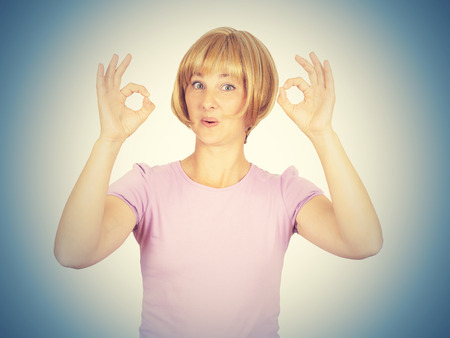 Beautiful happy young woman showing Ok sign isolated on background. Positive human emotionsの写真素材
