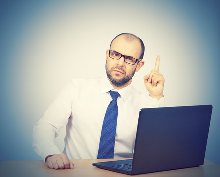 Portrait of businessman pointing finger up, showing something, having an idea.Isolated on white backgroundの写真素材