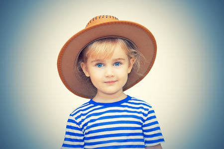 Little girl with hat on a white background.の写真素材