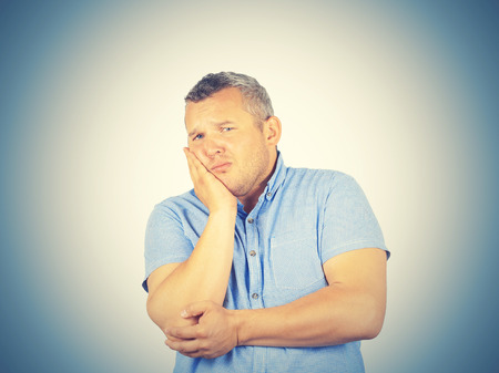Fat man with a toothache. Isolated on background.  の写真素材