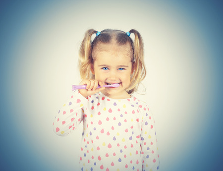 Little girl brushing her teeth. Girl with a toothbrush. Oral hygiene.の写真素材
