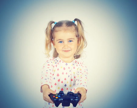Little girl playing video games with gamepad in the hands.の写真素材