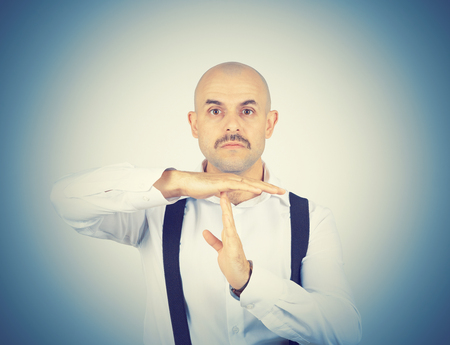 bald man showing time out hands gesture isolatedの写真素材