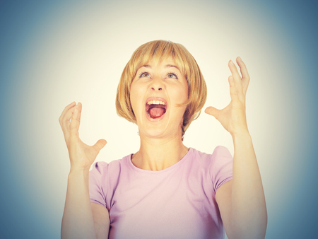 success concept - successful young blonde girl winning a competition with both hands raised up above head. Happy winner.  business womanの写真素材
