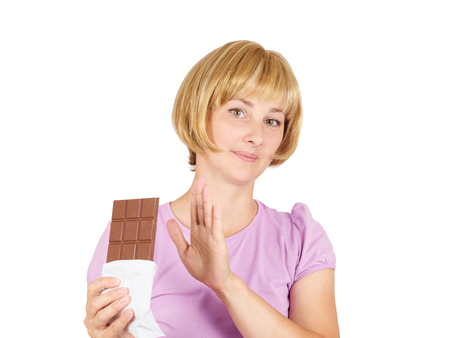 Portrait of young woman eat chocolate though. She exhausted diet. Greed sweet.  の写真素材