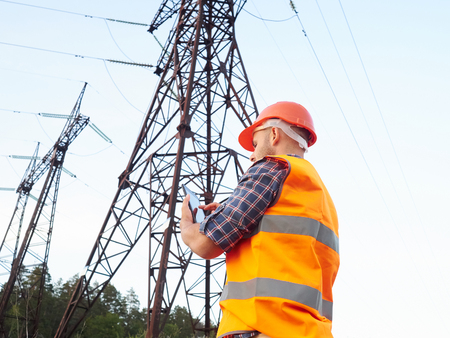 Electrical engineer working. Talking on the phone and working on the tablet.Checking the power grids.の写真素材