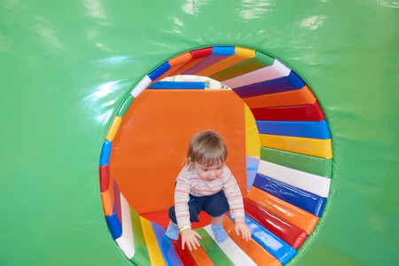 The One Year Old Baby Cute Playing In Indoors Playground. Active Toddler Boy Having Fun At Sport Center.の写真素材