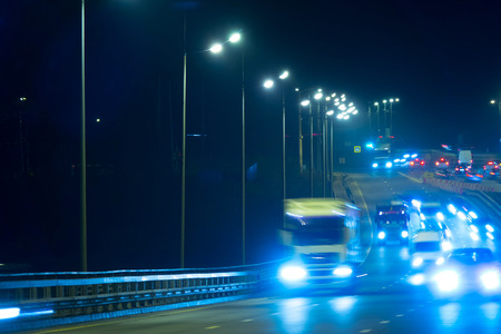 Highway traffic cars at night blured. Cars moving on road on bridge evening blurry.の写真素材