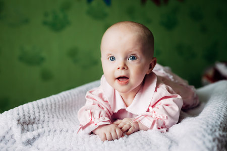 Little baby girl playing in the children's room at the day time. Baby girl is looking at the camera...
