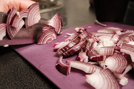 Slicing onions with a knife on a cutting board