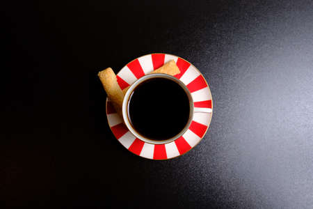 Coffee in a cup, cookies and black backgroundの写真素材