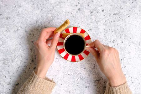 Coffee in a cup, cookies and female handsの写真素材