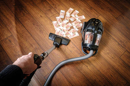 The cash vacuum cleaner picks up the moneyの写真素材