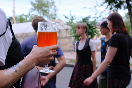Velikiy Novgorod, Russia, Aleksandr Kirillov - 02052020: Glass of beer in hands and people in the...