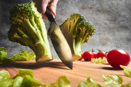 Knife cuts fresh cabbage on the boardの写真素材