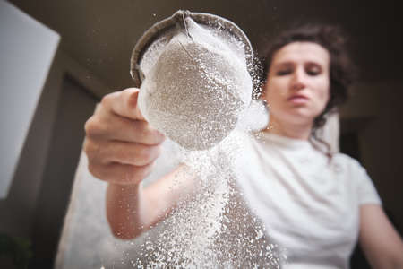 Flour is sieved with a metal sieveの写真素材