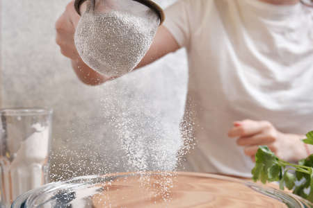 Flour is sieved with a metal sieveの写真素材
