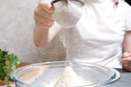 Flour is sieved with a metal sieveの写真素材