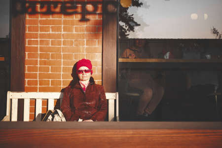 Adult woman in red sunglasses with closed eyes enjoying the sunのeditorial素材