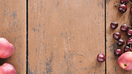 Fruit on a wooden table. Ripe peaches and juicy cherries are lying on a wooden table