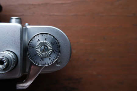 Old vintage 35 mm metal film camera, close-up. The wheel of rewinding frames in close-up. Space for...