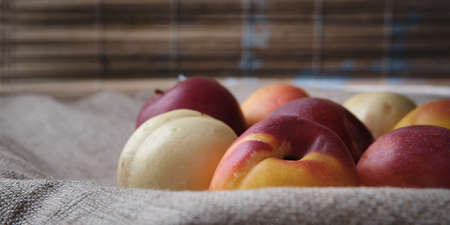 Juicy fruits in a linen tablecloth. Red, orange, white Plums and apricots on a background.の写真素材