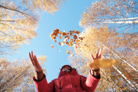 A Woman in A Red Jacket Throws Yellow Leaves. Autumn Landscape. Slow motion video.