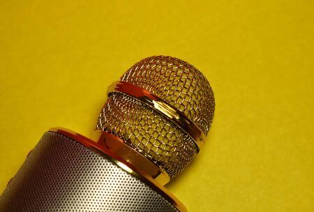 Part of a karaoke microphone on a yellow background close upの写真素材