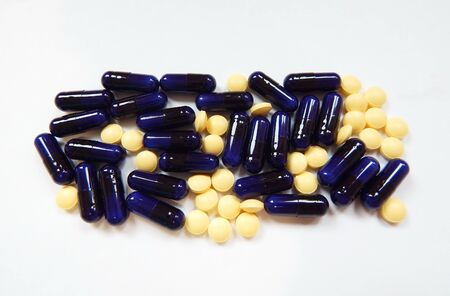 Beige tablets and blue capsulesの写真素材