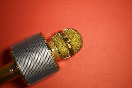 Gold metal karaoke microphone on red background close-up, copy space.の写真素材