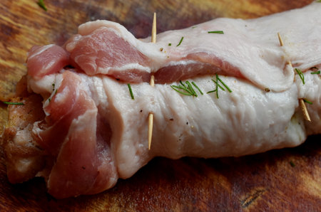 Raw pork fillet roll on a wooden boardの写真素材