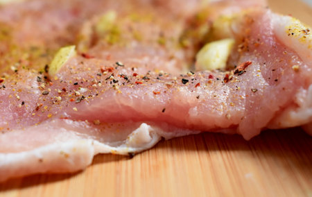 A piece of raw pork fillet with spices on a cutting boardの写真素材