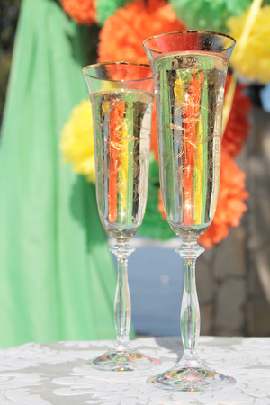 Two wedding glasses of champaign on the colorful backgroundの写真素材