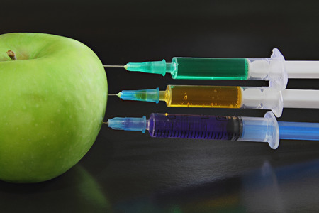 Green apple with syringes on the black backgroundの写真素材