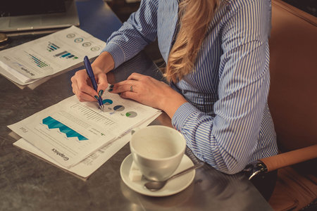 View of businesswoman hands , she sitting at the table and write on papper