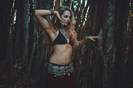 Girl in ethnic dress dancing on the background of the sacred banyanの写真素材