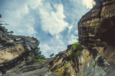 In the front big cliff on background blue sky with cloudsの写真素材