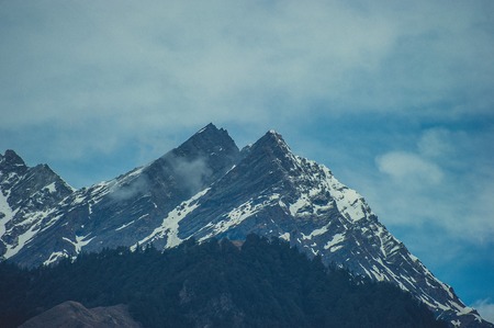 In the front pine woods on background Himalayan mountans and sky with cloudsの写真素材