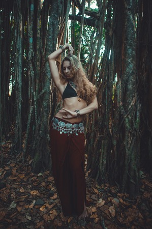 European girl in oriental dress dancing against the background of banyan.の写真素材