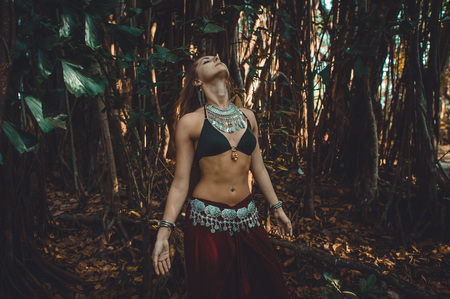 European girl in oriental attire with her head raised up against the background of banyan tree.の写真素材