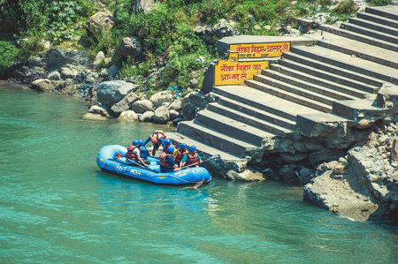 Rishikesh. India. April 12, 2017: People in a blue boat moored to the shore after rafting on the...