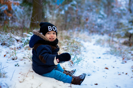 Little boy walking in the winter forestの写真素材