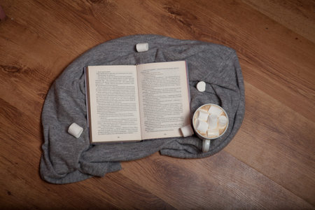 Open book and hot fragrant coffee on a wooden background.