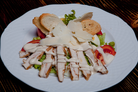 Tasty salad with croutons, chicken breast, grated parmesan cheese, just a healthy recipe. Caesar salad with chicken breast, salad mix, egg, fresh tomatoes, croutons, chicken breast grilled and parmesanの写真素材
