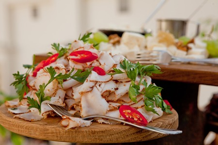 A delicious slice of pork bacon with spices, decorated with parsley on a wood board. Wedding tableの写真素材