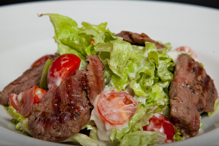 Veal salad, salad with large slices of veal and fresh vegetables on a plate.の写真素材