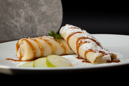 Pancakes with apples on a black background. Restaurant menu.の写真素材