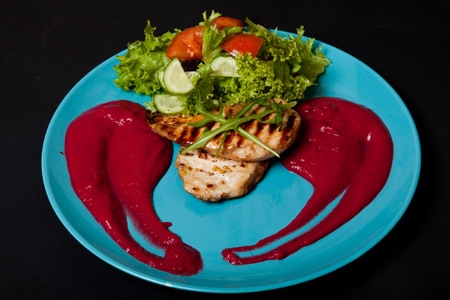 Chicken fillet cooked with mashed potatoes on a black background.の写真素材